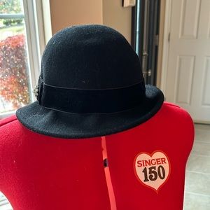 Black hat with side broch and felt band.